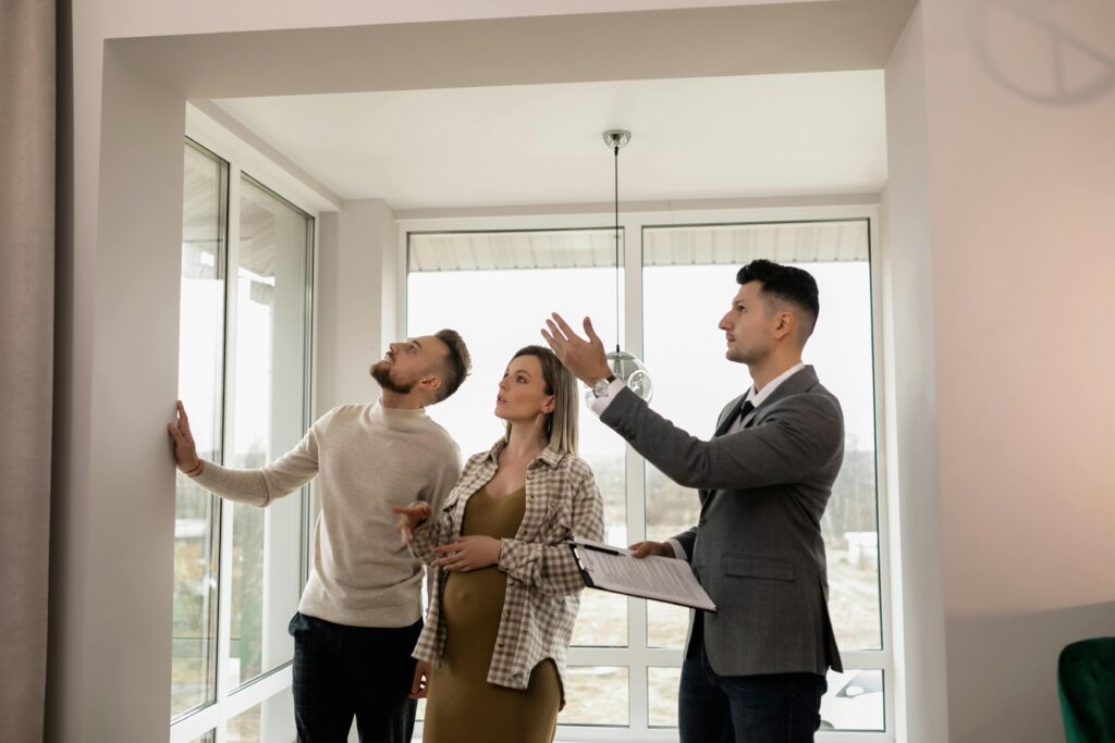 pexels-photo-7641868-7641868 A young couple inspects a modern apartment with a real estate agent during a daytime viewing.